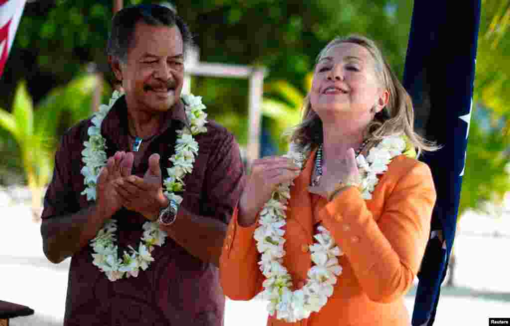 Ngoại trưởng Clinton đeo chuổi hạt trai đen, tặng phẩm của Thủ tướng Henry Puna (trái) của quần đảo Cook, khi bà đến dự một hội nghị trên đảo Rarotonga (thuộc quần đảo Cook), 31-82012