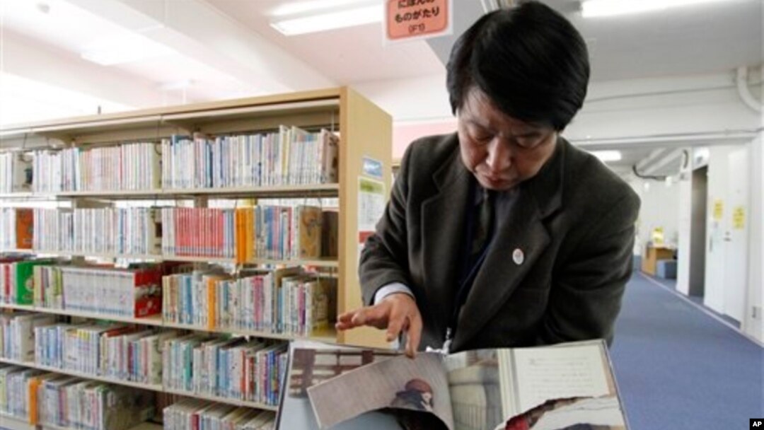 A ripped copy of Anne Frank's "Diary of a Young Girl" picture book is shown by Shinjuku City Library Director Kotaro Fujimaki at the library in Tokyo Friday, Feb. 21, 2014. 