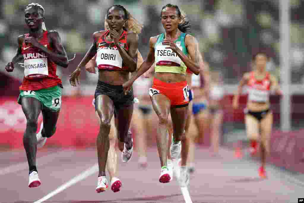 Gudaf Tsegay, of Ethiopia, right, crosses the finish line ahead of Hellen Obiri of Kenya, 2nd left, to win a heat in the women's 5,000-meter run at the 2020 Summer Olympics, Friday, July 30, 2021, in Tokyo. (AP Photo/Petr David Josek)