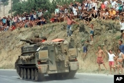 ARHIVA - Albanske izbeglice u Makedoniji pozdravljaju britanski tenk na putu ka Kosovu, 12. juna 1999. godine (Foto: AP/Boris Grdanoski)