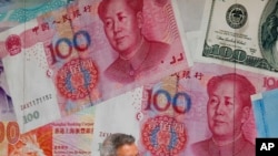 一百元面值的人民幣和美元。（美聯社示意圖）