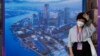 Seorang perempuan mengenakan masker saat berada di sebuah area di Shanghai, pada 6 Juli 2023. (Foto: AP/Ng Han Guan)