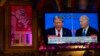 FILE - Presiden Joe Biden (kanan) dan calon presiden dari Partai Republik mantan Presiden Donald Trump (kiri), ditayangkan di layar televisi Tillie's Lounge, Cincinnati, saat berlangsungnya debat presiden, Kamis, 27 Juni 2024. (AP/Carolyn Kaster)