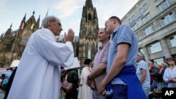 FILE - Same-sex couples take part in a public blessing ceremony in front of the Cologne Cathedral in Cologne, Germany, on Sept. 20, 2023. 