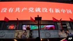 北京一家商場樹立的宣傳牌上寫著“沒有共產黨就沒有新中國”的口號。（2015年2月6日）