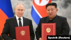 俄罗斯总统普京与朝鲜领导人金正恩在平壤举行的签字仪式上合影。（2024年6月19日）
