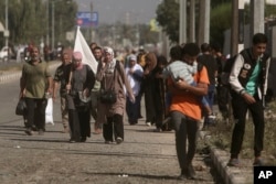 Žena nosi belu zastavu kako bi sprečila da u nju bude pucano, dok Palestinci napuštaju grad Gazu i idu ka jugu, u Bureju, 7. novembra 2023.