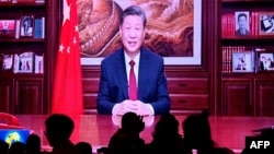 2023 年 12 月 31 日，大眾在一家餐廳吃晚飯，屏幕上播放著中國國家主席習近平在北京發表新年講話的畫面。(法新社)
