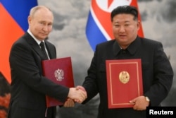 2024년 6월 19일 북한을 방문 중인 블라디미르 푸틴 러시아 대통령과 김정은 북한 국무위원장이 포괄적 전략동반자 협정에 서명 후 악수를 나누고 있다.
