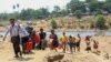 FILE - People cross the Moei river as they flee Myawaddy township in Myanmar to Thailand's Mae Sot town in Thailand's Tak province, April 20, 2024. 