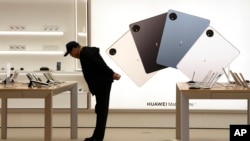A customer looks at the products displayed at a Huawei flagship store in Beijing, March 23, 2023.