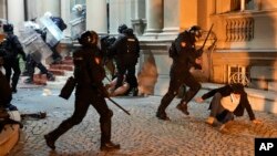 Policajci tuku i privode učesnike protesta protiv izbornih nepravilnosti, tokom skupa ispred Skupštine Grada Beograda, u Beogradu, 24. decembra 2023.