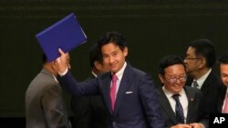 FILE - Leader of Move Forward Party Pita Limjaroenrat, left, waves after signing a memorandum of understanding on attempt to form a coalition government between Move Forward Party and other parties during a news conference in Bangkok, Thailand, May 22, 2023.