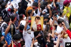 ชาวเมียนมาที่อาศัยอยู่ในประเทศไทยชูภาพของ ออง ซาน ซู จี ระหว่างเข้าร่วมการชุมนุมประท้วงในกรุงเทพฯ เพื่อรำลึกวันครบรอบ 2 ปี การก่อรัฐประหารยึดอำนาจโดยกองทัพ เมื่อวันที่ 1 ก.พ. 2023 (AP)