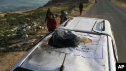 Palestinci istražuju vozilo sa logoom Svetske centralne kuhinje na krovu, uništeno u izraelskom vazdušnom udaru u Deil al Balahu, Pojas Gaze, 2. aprila 2024.