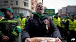 Dok – Seorang perempuan memegang roti saat protes petani di depan kantor perwakilan Komisi Eropa di Bucharest, Romania.