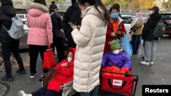 北京一家儿童医院外排队等候看病的儿童和家长。（2023年11月27日）