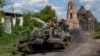 Ukrainian soldiers ride atop an armored vehicle in Ukraine's Sumy region, close to the country's border with Russia, Aug. 14, 2024.