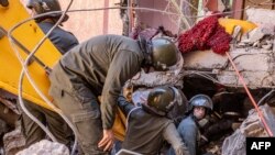 Rescue workers search for survivors in a collapsed house in Moulay Brahim, Al Haouz province, Morocco, after an earthquake, Sept. 9, 2023.