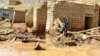 An Afghan man collects his belongings from his damaged home after heavy flooding in Ghor province in western Afghanistan, May 18, 2024.
