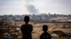 Anak laki-laki menyaksikan kepulan asap di tengah serangan Israel di timur Rafah di Jalur Gaza selatan pada 13 Mei 2024. (Foto: AFP)