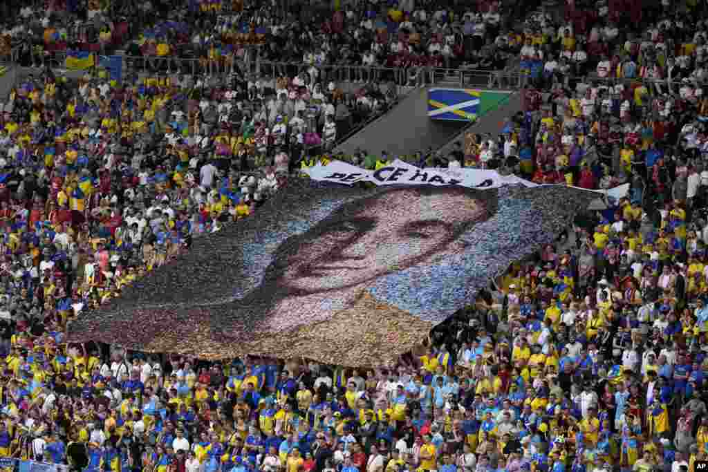 Ukraine fans display a banner reading 'Peace has a price' and a portrait of Nazariy Hryntsevich, a fallen soldier and a football fan, during a Group E match between Ukraine and Belgium at the Euro 2024 soccer tournament in Stuttgart, Germany.