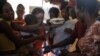 People crowd in for plates of food for their children at a shelter for families displaced by gang violence, in Port-au-Prince, Haiti, March 22, 2024.
