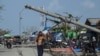 ဆိုင်ကလုန်းမုန်တိုင်း မိုခါဝင်ရောက်တိုက်ခတ်အပြီး စစ်တွေမြို့ပေါ်မှာ လဲကျသွားတဲ့ ဓါတ်တိုင်နဲ့ လမ်းသွားလမ်းလာတဦးကိုတွေ့ရစဉ် (မေ ၁၇၊ ၂၀၂၃)
