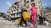 Anak-anak Palestina berjalan melewati sebuah bangunan yang rusak akibat serangan Israel, di tengah konflik yang sedang berlangsung antara Israel dan Hamas, di Rafah, di selatan Jalur Gaza, 1 Mei 2024. (Foto: Reuters)