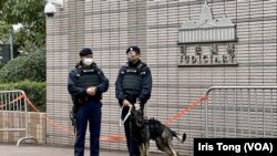在西九龍裁判法院外駐守的警員牽著的警犬都穿上防刺的裝備。 (美國之音 湯惠芸)