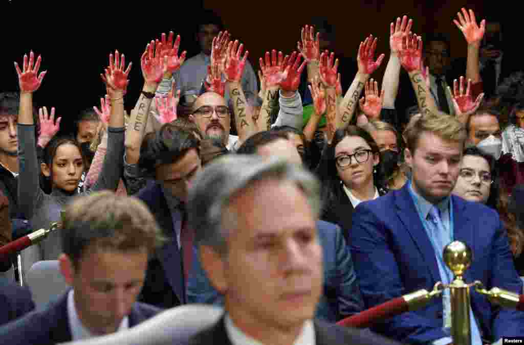 Anti-war protesters raise their "bloody" hands behind U.S. Secretary of State Antony Blinken during a Senate Appropriations Committee hearing on President Biden's $106 billion national security supplemental funding request to support Israel and Ukraine, as well as bolster border security, on Capitol Hill in Washington, Oct. 31, 2023.