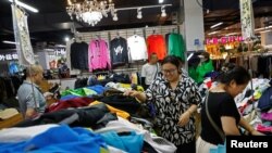 ภาพผู้บริโภคชาวจีนที่ออกมาจับจ่ายหาซื้อเสื้อผ้าในตลาดค้าส่งแห่งหนึ่งในกรุงปักกิ่ง เมื่อวันที่ 8 ก.ย. 2023 [REUTERS]