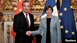 2023年2月15日中共中央外事辦公室主任王毅在法國巴黎出席會議時與法國外交和歐洲事務部長凱瑟琳·科隆納握手