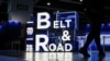 FILE - A woman walks in front of a sign at the 'Belt and Road' summit in Hong Kong, Sept. 14, 2023. What started as an effort to rebuild old Silk Road trade routes through Central Asia is now reaching every continent and the North and South Pole regions.