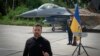 Ukraine's President Volodymyr Zelenskyy answers media questions standing against the backdrop of an F-16 fighter jet at an undisclosed location in Ukraine, Aug. 4, 2024.