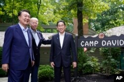조 바이든 미국 대통령과 윤석열 한국 대통령, 기시다 후미오 일본 총리가 18일 미국 캠프 데이비드에서 3자 정상회의에 앞서 기념촬영을 했다.