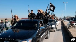 FILE - IS militants are seen in Tel Abyad, Syria, May 4, 2015. There are concerns about an upswing in Islamic State attacks across Syria, though the United States has expressed skepticism about their significance. (Militant website via AP)