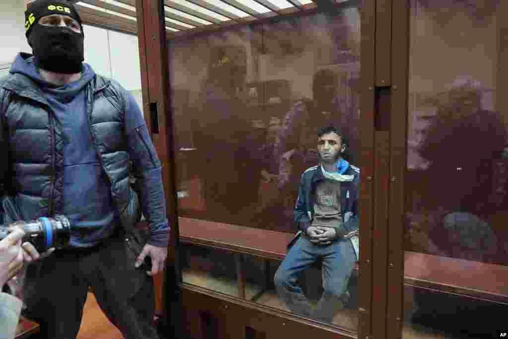 Dalerdzhon Mirzoyev, a suspect in the Crocus City Hall shooting on Friday, sits in a glass cage in the Basmanny District Court in Moscow, Russia, March 24, 2024.