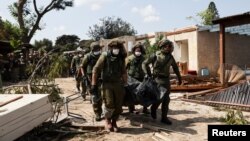 以色列士兵在以色列南部Kibbutz Kfar Aza地区抬着被巴勒斯坦武装分子杀害的以色列平民的遗体。（2023年10月10日）