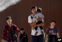 ARHIVA - Migranti, među kojima su Kinezi, hodaju posle prelaska američke granice sa Mekskom kako bi zatražili azil u Kaliforniji, 24. oktobra 2023.