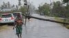 This handout photograph taken and distributed by UNICEF on March 12, 2023 shows a woman walking along a street damaged by the impact of Cyclone Freddy in the city of Quelimane.