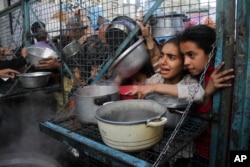 Warga Palestina antre untuk menerima makanan gratis di kamp pengungsi Jabaliya di Jalur Gaza, 18 Maret 2024. (Foto: AP)