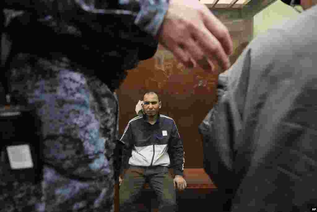 Saidakrami Rachabalizoda, a suspect in the Crocus City Hall shooting on Friday, sits in a glass cage in the Basmanny District Court in Moscow, Russia, March 24, 2024.