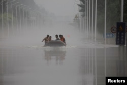 中國河北涿州民眾在滔滔洪水中乘坐橡皮艇逃生。 （2023年8月3日）