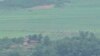North Koreans work on a field near a North Korean military guard post, seen from the Unification Observation Post in Paju, South Korea, near the border with North Korea, July 21, 2024. 