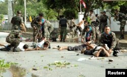 FILE - Thai soldiers apprehend men after demonstrators clashed with police outside the Tak Bai police station in Thailand's Narathiwat province on Oct. 25, 2004, in what has become known as the Tak Bai Massacre.