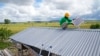Antonius Makambombu, seorang pekerja dari organisasi Sumba Sustainable Solutions tampak memperbaikin panel surya di atap rumah warga di desa Laindeha, Sumba, pada 22 Maret 2023. (Foto: AP/Dita Alangkara)