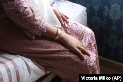 B, usia 14 tahun, duduk di tempat tidur sebuah apartemen di Kuala Lumpur, Malaysia, pada 4 Oktober 2023. B datang ke Malaysia pada 2023 untuk menikah dengan pria yang lebih tua. (AP Photo/Victoria Milko)