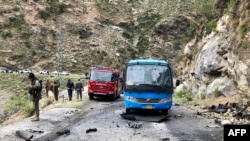 Security personnel inspect the site of a suicide attack near Besham city in the Shangla district of Khyber Pakhtunkhwa province on March 26, 2024.
