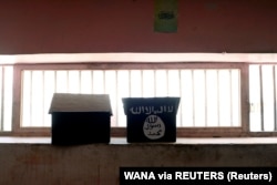 Bendera ISIS yang dilukis di atas rak buku terlihat di sel penjara Pul-e-Charkhi di Kabul, Afghanistan, 15 September 2021. (Foto: WANA via REUTERS)